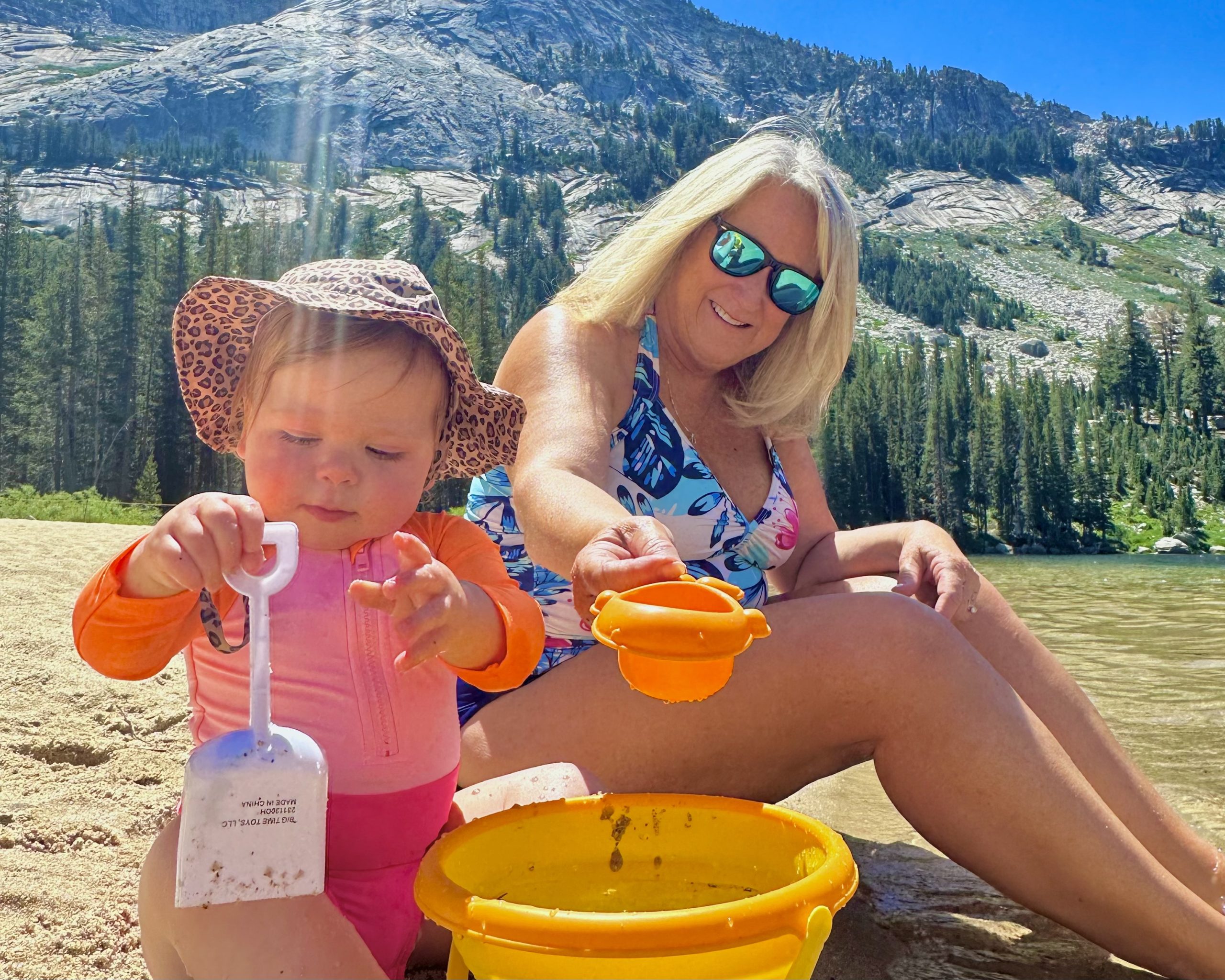 woman playing with baby in the sand